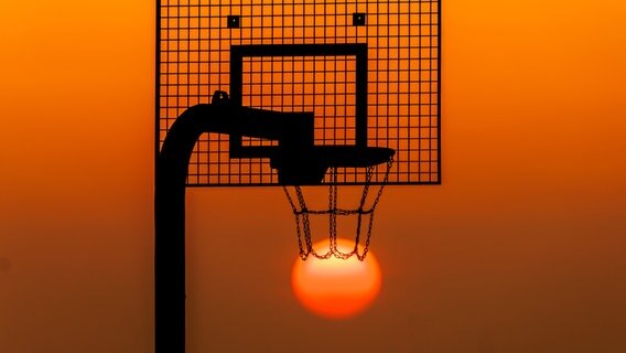 Die Sonne geht hinter einem Basketballkorb auf. © NDR Foto: Andy Bünning aus Torgelow