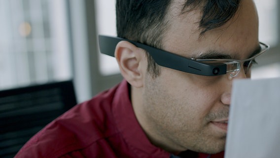Ein Mann nutzt eine KI-gesteuerte Brille für sehbehinderte und blinde Menschen. © Envision Glasses Foto: Sadjad Frogh