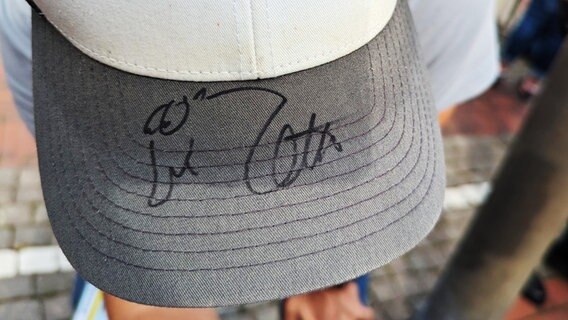 Otto hat die Mütze eines Fans mit Unterschrift und Ottifant signiert. © NDR Foto: Sebastian Duden