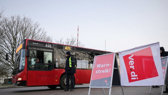 Ein Schild mit der Aufschrift "Warnstreik" steht vor einem Bus des Verkehrsbetriebs Autokraft in Kiel. © dpa Bildfunk Foto: Christian Charisius