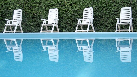 Ein leerere Swimmingpool mit Liegestühlen am Beckenrand. © krockenmitte / photocase.de Foto: krockenmitte