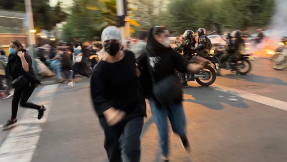 Frauen fliehen bei Protesten in der iranischen Hauptstadt Teheran vor der Polizei. © AP/dpa 