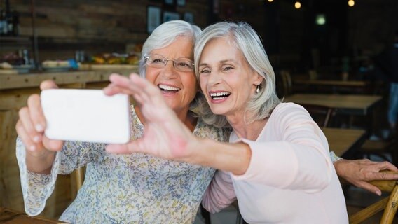 Zwei ältere Frauen machen zusammen ein Selfie. © picture alliance / Zoonar Foto: Channel Partners