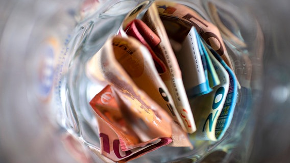 Verschiedene Geldscheine stecken in einem Behältnis. © picture alliance / Wedel/Kirchner-Media | Wedel/Kirchner-Media 