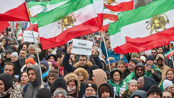 Teilnehmer einer Demonstration gegen das iranische Regime halten auf dem Glockegießerwall iranische Flaggen und ein Transparent mit der Aufschrift "Stoppt Hinrichtungen". © picture alliance/dpa Foto: Georg Wendt