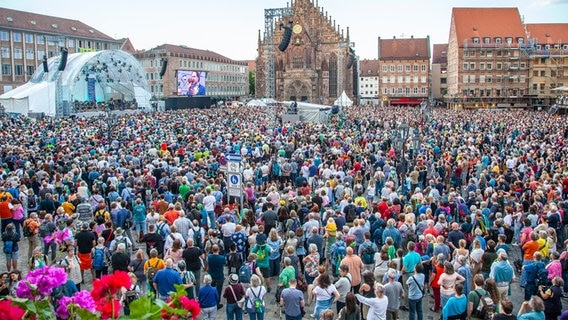 Unter freiem Himmel feiern Menschen gemeinsam den Abschlussgottesdienst beim Kirchentag 2023 in Nürnberg. © Christine Raczka / Kirche im NDR Foto: Christine Raczka