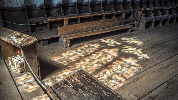 Ein Kirchenfenster reflektiert auf einem Holzboden. © Kirche im NDR Foto: Christine Raczka