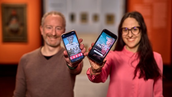 Hartwig Dingfelder und Jasmin Mickein von der Kunsthalle Bremen halten ihre Handys in die Kamera. Sie zeigen die beiden neuen Web-Apps, die sie entwickelt haben. © Kunsthalle Bremen Foto: Marcus Meyer Photography