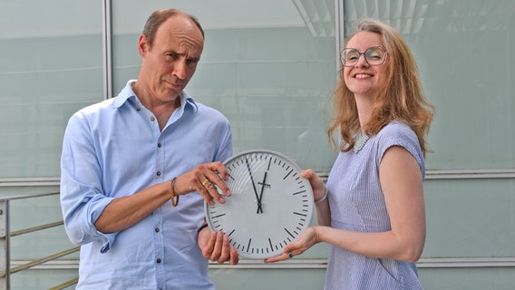NDR Redakteur Ocke Bandixen (links) hält an einer Uhr fest - sowie auch NDR Redakteurin Juliane Bergmann © NDR Foto: Patricia Batlle
