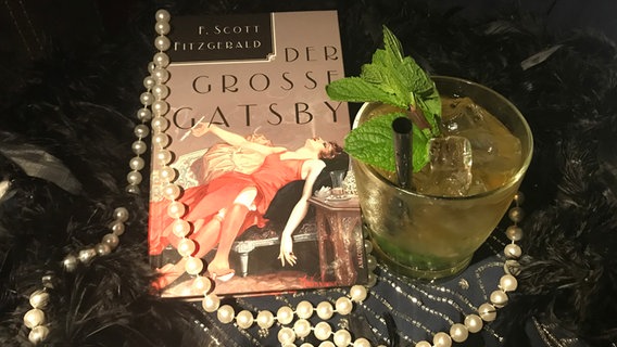 Mint Julep neben einer Ausgabe von "Der große Gatsby" mit einer Perlenkette - Podcast "eat.READ.sleep" Folge 8 © NDR Foto: Katharina Mahrenholtz