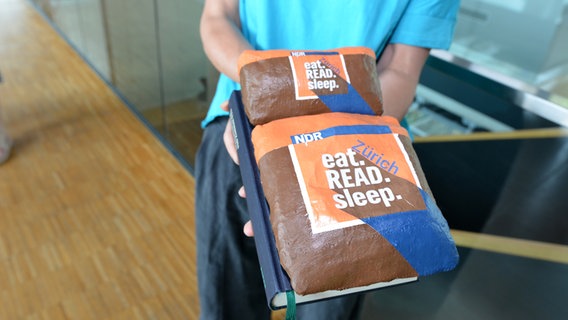 Ein Buch mit der Aufschrift "eat.READ.sleep." in den Händen einer Frau © NDR Foto: Patricia Batlle