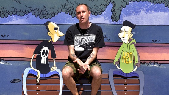 Der Cartoonist Zerocalcare sitzt neben seine Comic-Figuren auf einer Bank © picture alliance / Rocco Spaziani | Rocco Spaziani Foto: Rocco Spaziani
