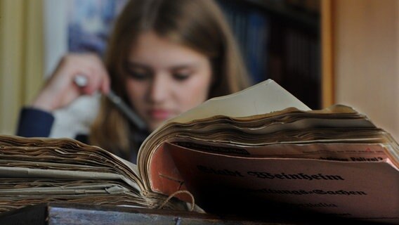Ein Mädchen sitzt vor einem aufgeschlagenen Buch © David Ausserhofer Foto: David Ausserhofer