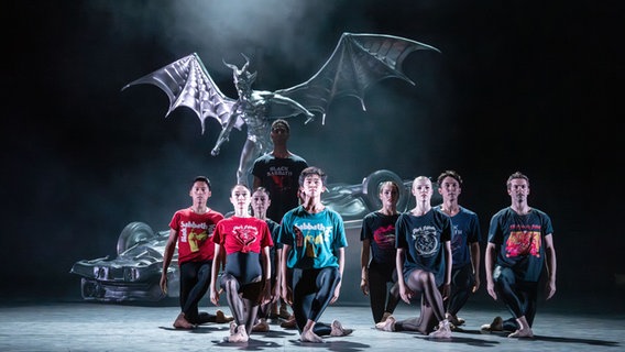 Neun Balletttänzerinnen und -tänzer in Black-Sabbath-T-Shirts vor einer Teufelsskulptur Neun Balletttänzerinnen und -tänzer in Black-Sabbath-T-Shirts vor einer Teufelsskulptur © Birmingham Royal Ballet/ Johan Persson Foto: Johan Persson