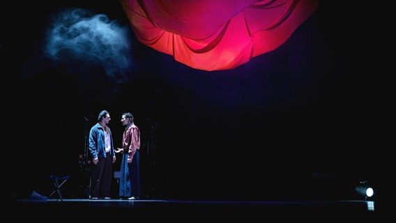 Eine Frau und ein Mann stehen auf einer Theaterbühne und sehen sich an © Schlosstheater Celle/ Marie Liebig 