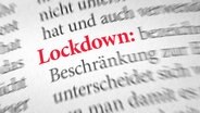 Ein aufgeschlagenes Wörterbuch, in dem der Begriff "Lockdown" rot markiert ist. © picture alliance / Shotshop | Zerbor 
