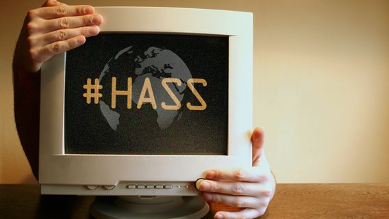 Ein Monitor, der von Händen umgriffen wird mit der Aufschrift "#Hass" und einer Weltkugel. © photocase, fotolia Foto: spacejunkie, senoldo