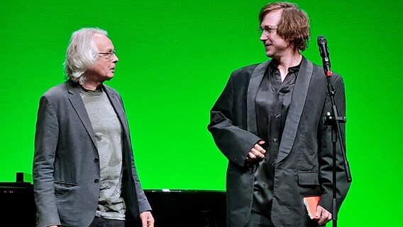 Lars Eidinger und Hans-Jörn Brandenburg vor einem grünen Hintergrund. © NDR Foto: Agnes Bührig