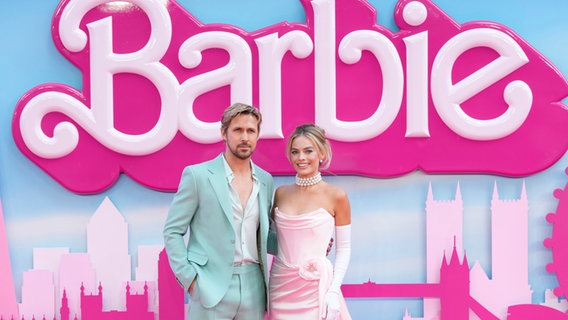Margot Robbie und Ryan Gosling in jeweils türkis und rosa gekleidet bei einer Filmpremiere von "Barbie" © Scott Garfitt/Invision/AP/dpa +++ dpa-Bildfunk +++ Foto: Scott Garfitt