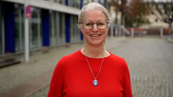 Die Autorin Isabel Bogdan steht auf der Straße und trägt einen roten Pulli. © NDR 90,3 Foto: Marco Peter