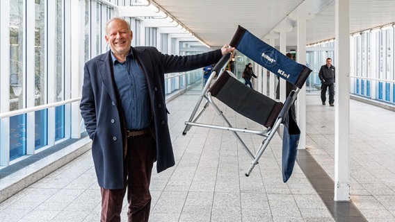 Axel Milberg hält einen Stuhl mit der Aufschrift "Tatort Kiel" hoch. © picture alliance/dpa Foto: Markus Scholz
