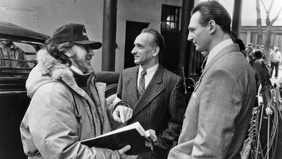 Regisseur Steven Spielberg (links) am Set von "Schindlers Liste" im Jahr 1993 mit Sir Ben Kingsley (Mitte) und Liam Neeson © Image courtesy Ronald Grant Archive / Mary Evans Picture Library via www.imago-images.de 