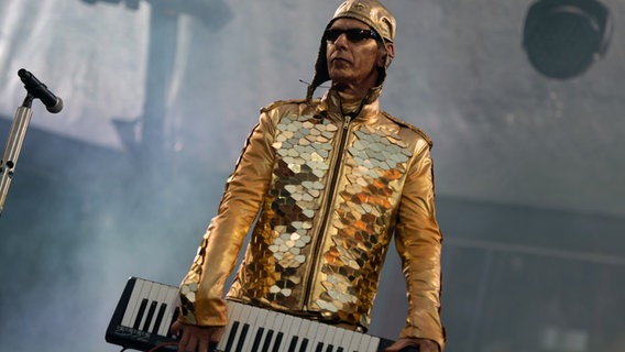 Christian Flake Lorenz steht mit einem Keyboard in den Händen auf einer Bühne. © picture alliance/dpa | Christophe Gateau 