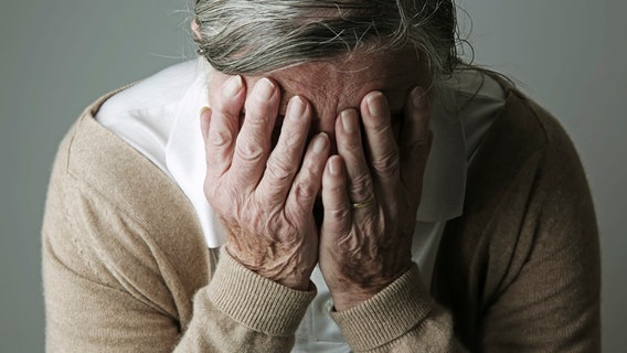 Eine ältere Frau hält ihre Hände vors Gesicht © picture alliance / Westend61 Foto: Jan Tepass