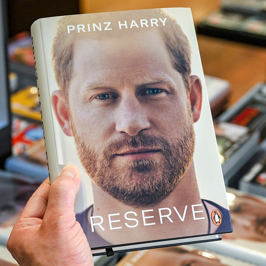 Jemand hält Prinz Harrys Autobiografie "Spare" in der Hand. © picture alliance/dpa Foto: Jens Kalaene