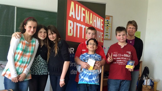 Schüler der Albert-Liebmann-Schule in Hannover posieren in ihrer Klasse vor einem "Aufnahme - Bitte Ruhe"-Schild. © NDR Foto: Janine Lüttmann