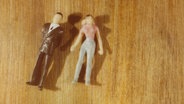 Zwei Spielfiguren, die Mann und Frau darstellen, liegen auf dem Boden. © pontchen / photocase.de Foto: pontchen