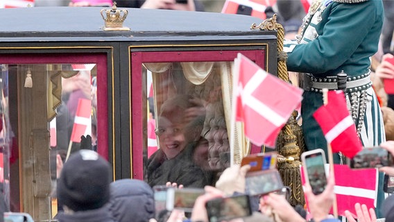 Königin Margrethe hat soeben ihre Abdankung unterzeichnet und fährt in einer Karrosse zum Schloss Amalienborg, die Straße ist gesäumt von Menschen mit dänischen Fahnen © Foto: Martin Meissner/AP +++ dpa-Bildfunk +++ Foto: Martin Meissner