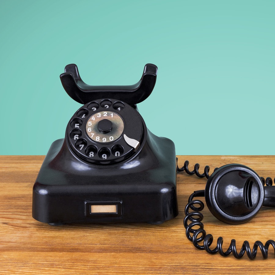 Ein altes Telefon steht auf einer Holzfläche, der Hörer ist abgenommen. © photocase Foto: pixelklex