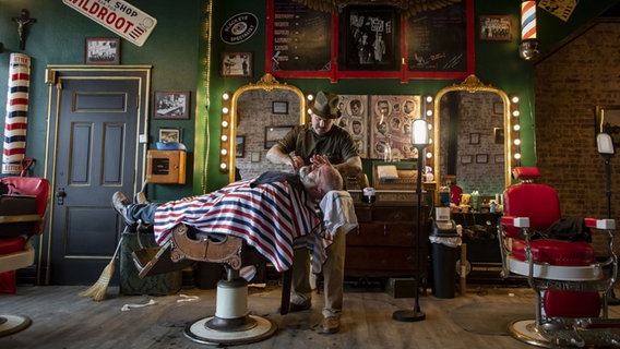 Ein Mann rasiert einem anderen Mann den Bart in einem Barbershop. © picture alliance / Chicago Tribune | Brian Cassella Foto: Brian Cassella