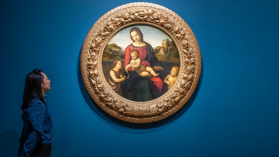 Frau betrachtet Bildnis der Madonna in einer Ausstellung © picture alliance / Photoshot 