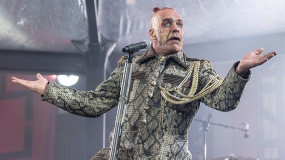 Till Lindemann hebt die Arme zur Seite hoch. © picture alliance/dpa | Boris Roessler 