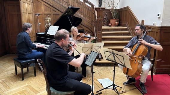 Drei Musiker mit Streichinstrumenten sitzen vor einem Flügel, der zwei Tastaturen hat, und spielen. Drei Musiker mit Streichinstrumenten sitzen vor einem Flügel, der zwei Tastaturen hat, und spielen. © NDR / Ulrike Henningsen Foto: Ulrike Henningsen