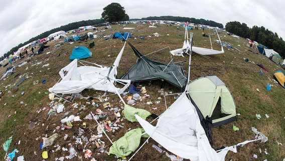 Auf einem Festivalgelände liegen viele zerstörte Pavillions und Zelte. © picture alliance/dpa Foto: Ole Spata/dpa
