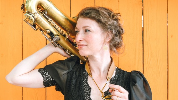 Eine Frau posiert mit einem Saxofon. © Stephanie Tarrant Foto: Stephanie Tarrant
