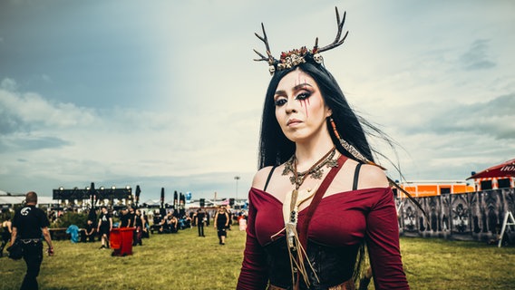 Eine Frau mit langen dunklen Haaren mit Geweih beim Festival bei M'era Luna 2023 © NDR Foto: Benjamin Hüllenkremer