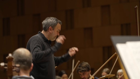 Jörg Widmann dirigiert ein Orchester © NDR Screenshots 
