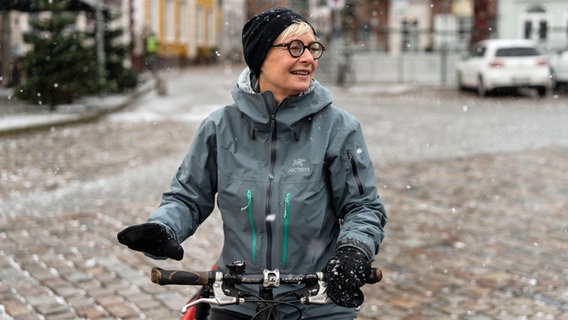 Bestsellerautorin Dörte Hansen sitzt lächelnd auf einem Fahrrad. © NDR/Lornz Lorenzen Foto: Lornz Lorenzen