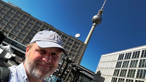 Blog-Autor Lornz Lorenzen macht ein Selfie in Berlin, im Hintergrund ist der Fernsehturm am Alex zu sehen. © NDR Foto: Lornz Lorenzen