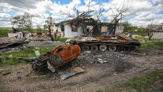 Ein ausgebrannter russischer Panzer liegt vor einem zerstörten Wohnhaus in dem Dorf Mala Rogan, östlich von Charkiw. © picture alliance/dpa/SOPA Images via ZUMA Press Wire Foto: Aziz Karimov