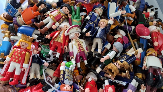 Viele bunte Spielfiguren von Playmobil mit unterschiedlicher Kleidung und verschiedenen Gegenständen liegen in einem Haufen aufeinander. © NDR Foto: Petra Volquardsen