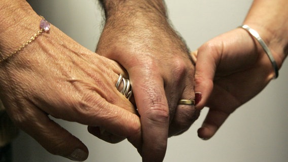 Männerhand hält zwei Frauenhände © picture-alliance / maxppp 