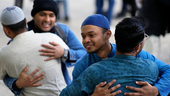 Muslimische Männer umarmen sich © Armando Franca/AP/dpa Foto: Armando Franca