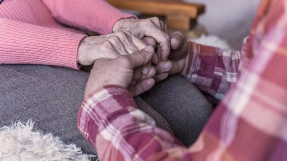 Ein Mann hält die Hände einer älteren Frau © picture alliance / Westend61 Foto: Ok Shu