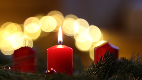 Eine Kerze brennt am ersten Advent an einem Adventskranz. © dpa Foto: Kar-Josef Hildenbrand