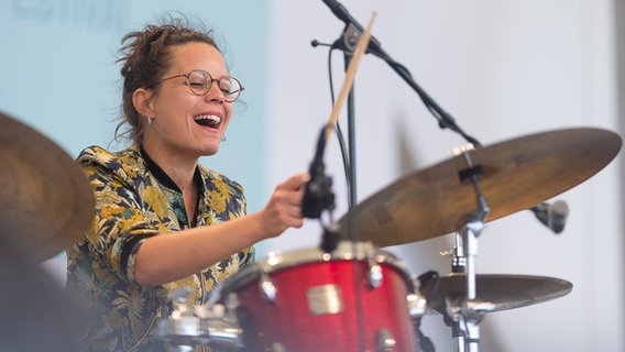 Die französische Schlagzeugerin Anne Paceo spielt ihr Instrument auf der Bühne des Pariser Jazz Festivals und lacht. © picture alliance / Denis Trasfi/MAXPPP/dpa Foto: Denis Trasfi